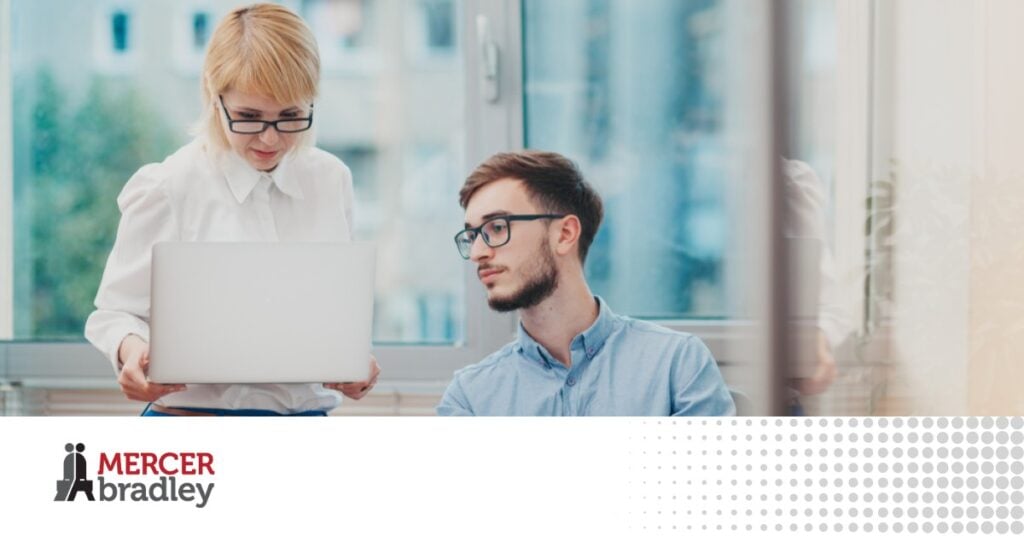 Manager reviewing information on a laptop with a new employee